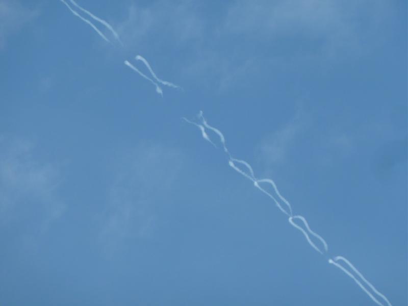 Hybrid contrails often end up looking like a string of chromosome pair. This turbulent flow of the aircraft wake would not be as apparent with the much larger exhaust contrail. 